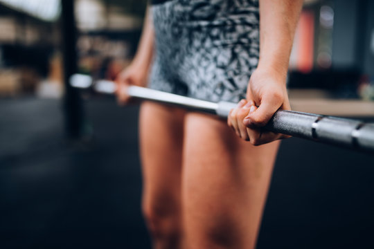 Close-Up of girl doing workout with barbell in Gym