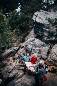 Group of mixed age people reading map with tour guide