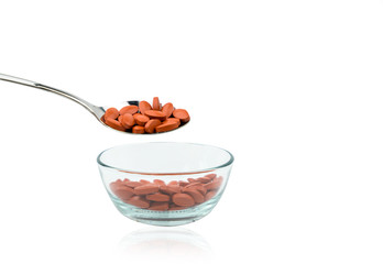 Iron tablets in spoon isolated on white background with copy space for text. Use for topics about treatment anemia in adult, elderly people and children. Blood donations concept.