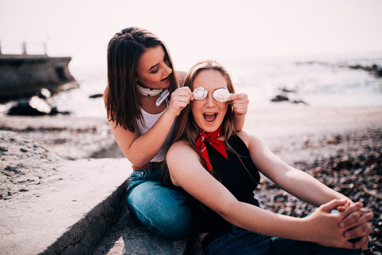 Teenager girls having fun pulling faces at the beach