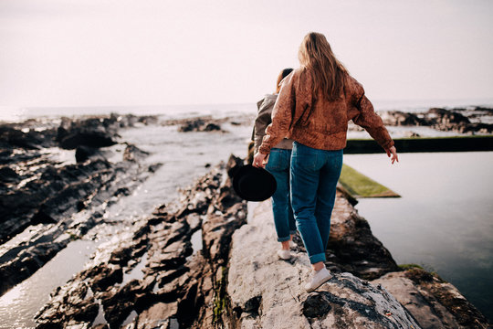 Tennager girls balancing on rocks on the beach