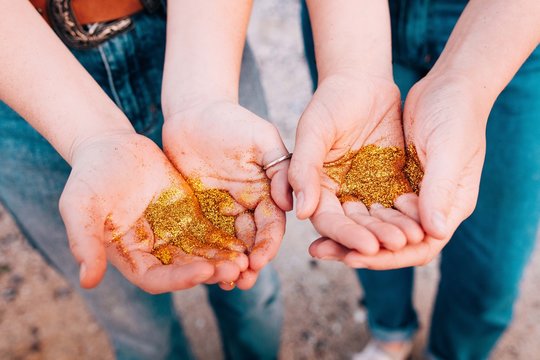 Close up of hands with golden glitter