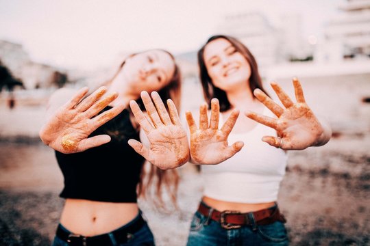 Teenage girls stretching out hands with golden glitter