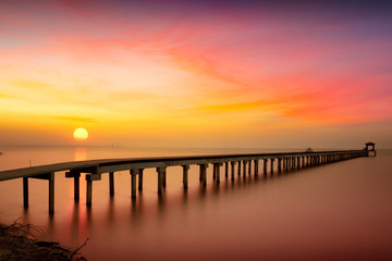 Fototapeta na wymiar Wooden bridge in the beautiful view on sea at sunset