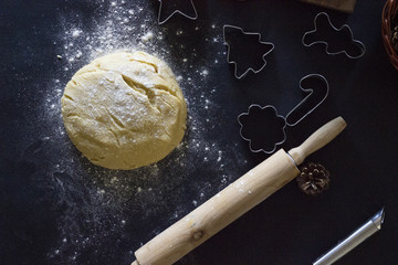 A dough and a rolling pin on a dark background