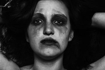 sad woman with smeared make up in dark, monochrome