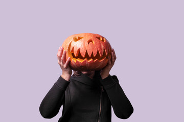 Woman holding a pumpkin halloween in front of the face