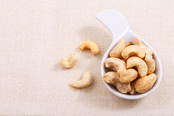 Organic raw Cashew nut in white ceramic bowl on base napkin