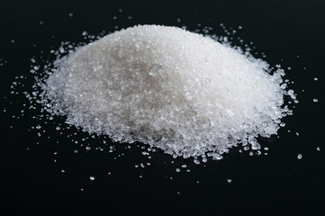 Fototapeta na wymiar Heap of granulated sugar isolated on black