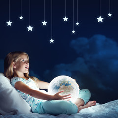 Naklejka premium Girl in her bed and glowing globe