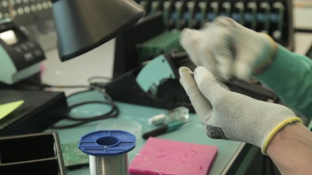 Woman holding pincette and soldering iron install electronic components on PCB (Printed circuit boards)