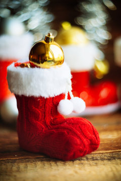 Christmas decoration.Red Santa's boot,fir tree,garland,gift,pine cones and Christmas balls.Christmas background.Soft selective focus.Winter holidays,Merry Christmas or Happy New Year concept.