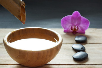 Set for spa procedures, stones for hot massage and flavored water, recruited from a bamboo stem into a bowl