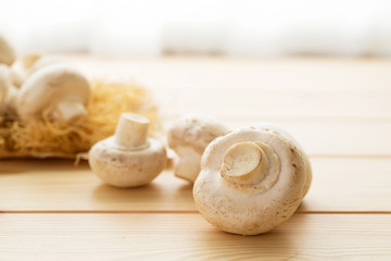 a group of raw champignon mushroom on wooden background
