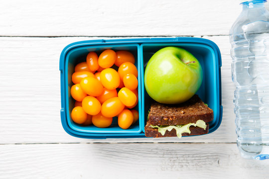 Image of cherry tomato, apple, sandwich in a container
