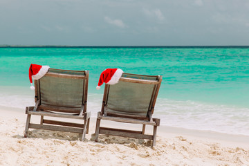 Christmas on beach -chair lounges with Santa hats at sea