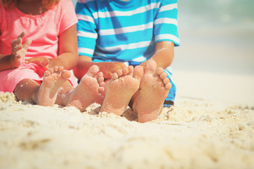 kids feet on sand beach, vacation concept