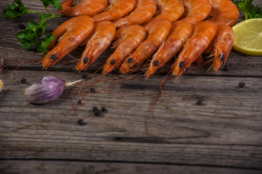 Selection of shrimps for dinner on wooden plate. Food background