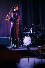 Fototapeta na wymiar Bearded saxophonist alone on stage