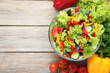 Vegetable salad in glass bowl on grey wooden table