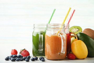 Sweet smoothie in glass jars with fruits on white background