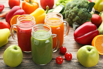 Vegetables smoothie in jars on wooden table