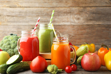 Obraz na płótnie Canvas Vegetables smoothie in jars on wooden table