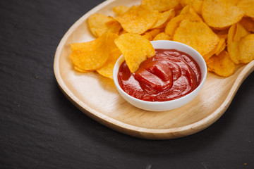 Fresh homemade crispy French fries on balck stone background.