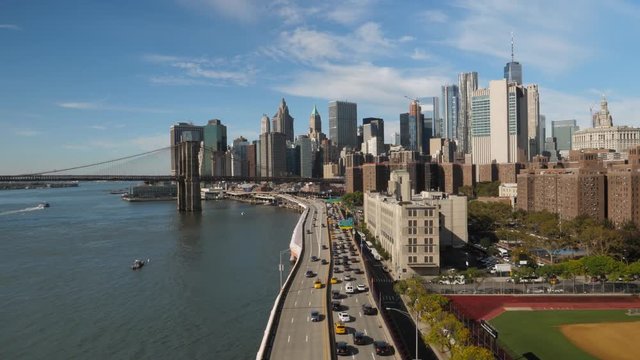 A high angle establishing shot of traffic on FDR Drive with the Manhattan skyline in the background.  