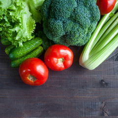 Fresh vegetables on the table. Broccoli, tomatoes, cucumbers, celery, salad. Square format. Space for text. top view