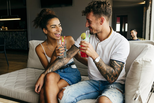 Couple with cocktails on sofa
