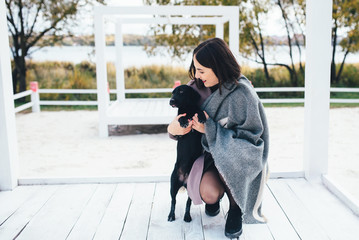 Autumn is coming. Beautiful young cute girl spending time with a dog on the terrace