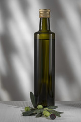 Olivenölflasche und frische Oliven