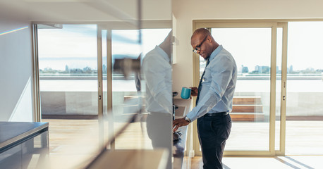 Businessman drinking coffee while preparing breakfast