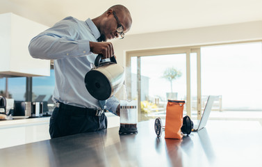 Businessman preparing coffee at home