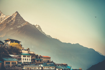Sonnenaufgangsansicht des Dorfes Namche Bazaar und des Thamserku-Berges, Khumbu-Tal, Nepal. Trekkingroute zum Everest Base Camp, Himalaya. Reisehintergrund. Schöne Naturlandschaft. Retro-Vintage-Tonung