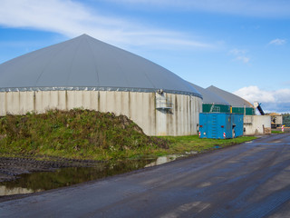 Biogas energy plant on farm in countryside with blue sky, Schleswig-Holstein, Germany