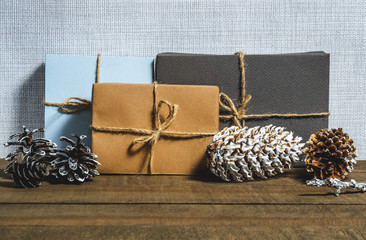 Boxes with gifts, cones, free space  on a wooden background