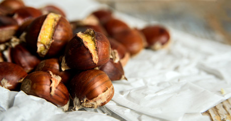 roasted chestnuts on paper. close up and selective focus with copy space