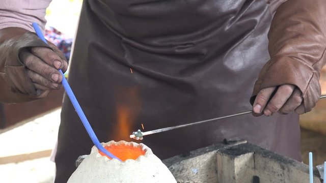 4K video footage of reenactment of ancient times. Process of making glass beads on the fire. Manufacturer of jewelry