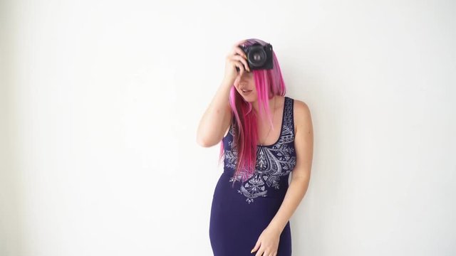 girl with pink hair makes photos on the vintage camera