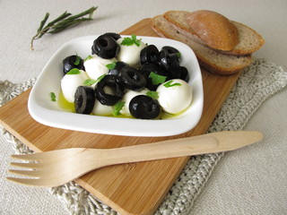 Marinierter Mozzarella mit schwarzen Oliven, Olivenöl und Blattsenf