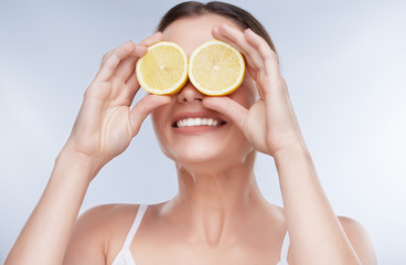 Woman closing eyes with two yellow lemons