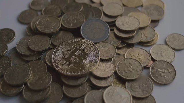 Gold Bitcoin Coin Drop over Euro Coins in Slow Motion
