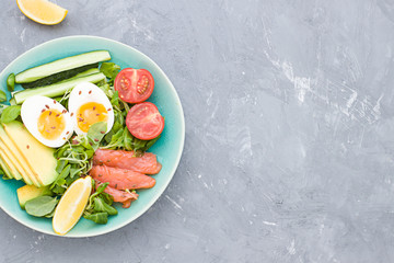 Healthy salad  frame with avocado, corn salad, smoky salmon, eggs and tomatoes for breakfast. Top view. Copy space