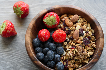 Homemade  granola with  fresh berry in wooden bowl