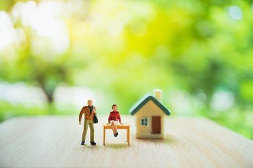Miniature people, man and woman stay in front of house, use for business and relationship concept