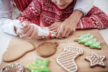Cute child enjoying process of decorating holiday pastry