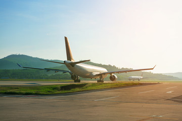 Fototapeta na wymiar Big passenger airplanes on runway strip are taxiing for take-off
