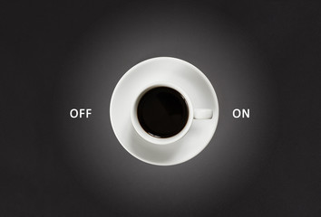 Coffee in white cup with a lettering on and off on black slate background